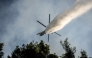 A firefighting helicopter drops water over a wildfire in the area of Porto Germeno, some 70 kilometres (45 miles) northwest of Athens in the region of Viotia, on August 2, 2026. (Photo by Angelos TZORTZINIS / AFP)