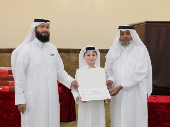 A student receives a certificate from officials at the end of the summer programme.