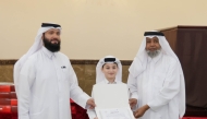 A student receives a certificate from officials at the end of the summer programme.