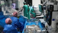 This photo taken on July 3, 2026 shows surgeons and nurses using the new Da Vinci 5 robotic-assisted surgical system while performing surgery, at St Bartholomew's Hospital in London. (Photo by Carlos Jasso / AFP)