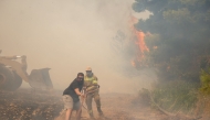 Volunteers and firefighters work to extinguish a wildfire in the Veniza area, west of Athens, in the Viotia region, on August 2, 2026. Photo by Aris Oikonomou / AFP