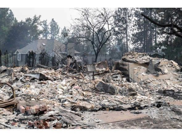 The rubble of a burned out residential home smolders in the Balboa neighborhood of Spokane, Washington, on August 2, 2026. Photo by Erick Doxey / AFP