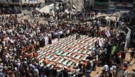 Palestinian mourners attend the funeral of members of the Abu Sharia and al-Hasayna families, whose remains were recently recovered from the rubble of residential buildings in the al-Sabra neighbourhood which were struck by Israeli bombardments in November 2023, in Gaza City on August 4, 2026. (Photo by Omar AL-QATTAA / AFP)