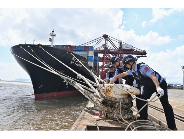 Police officers check the mooring lines of a vessel ahead of a typhoon in Beilun District of Ningbo City, east China's Zhejiang Province, (Photo by Hu Jiajie/Xinhua)