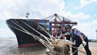Police officers check the mooring lines of a vessel ahead of a typhoon in Beilun District of Ningbo City, east China's Zhejiang Province, (Photo by Hu Jiajie/Xinhua)