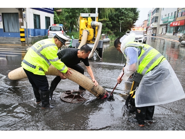 Staff members drain flood water from a water-logged road in Weishi County of Kaifeng, central China's Henan Province, Aug. 11, 2026. (Photo by Li Xinyi/Xinhua)