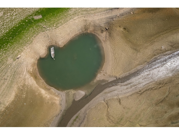 This aerial photograph shows the parched bed of Brenets Lake (Lac des Brenets), part of the Doubs River, a natural border between eastern France and western Switzerland, as central Europe is hit by a new heatwave, in Les Brenets on August 11, 2026. Photo by FABRICE COFFRINI / AFP