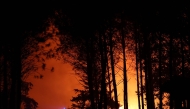 Firefighters battle a wildfire in the Landes forest in Luglon, south-western France, on August 13, 2026. Photo by ROMAIN PERROCHEAU / AFP
