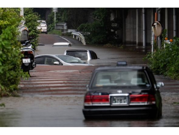 Abandoned cars are seen partially submerged on a flooded road in Sakura, Chiba prefecture on August 14, 2026. Photo by ANDREW CABALLERO-REYNOLDS / AFP