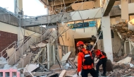 This handout picture taken and released on August 15, 2026 by Indonesia's National Search and Rescue Agency (BASARNAS) shows rescuers working amid the rubble of a damaged building after an earthquake in Maumere, East Nusa Tenggara. (Photo by Handout / INDONESIA'S NATIONAL SEARCH AND RESCUE AGENCY (BASARNAS) / AFP)