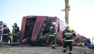 Rescue workers and other officials work at the wreckage of an overturned Polish tourist bus on the M3 motorway near Mezokeresztes, about 150 km east of the Hungarian capital Budapest, on August 16, 2026. Photo by Zoltan MATHE / MTI / AFP