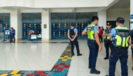 Philippine police gather at a school following a shooting in Zamboanga on August 18, 2026. A student was shot dead at a high school in the southern Philippines on August 18 before the alleged killer took his own life, police said. (Photo by Roel Parreno / AFP)