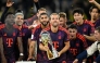 Bayern Munich's English forward #09 Harry Kane (C) holds the trophy as he celebrates with his teammates winning the Franz Beckenbauer Supercup football match between Borussia Dortmund and FC Bayern Munich on August 22, 2026 in Dortmund, western Germany. (Photo by INA FASSBENDER / AFP)