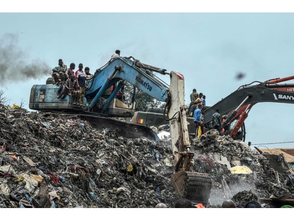 Residents and rescuers use an excavator to search for bodies after a landslide struck the Dar es Salaam dumpsite overnight in Conakry on August 23, 2026. (Photo by AFP)