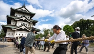 Participants pull Hirosaki Castle using ropes to its original position following repair works in Hirosaki, Aomori Prefecture on August 26, 2026. (Photo by Philip FONG / AFP)