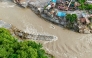 An aerial view shows a collapsed bridge along with houses lying deluged in sludge after flash floods at Devighat, Bidur Municipality in nepal's Nuwakot district on August 27, 2026.  (Photo by Prabin RANABHAT / AFP)