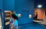 Visitors look at exhibits near a blue panel covering the area where a display case was smashed and a Van Cleef and Arpels necklace was stolen at Vienna's Museum of Applied Arts (MAK), in Vienna, Austria, on August 28, 2026. Photo by Jeremy AUDOUARD / AFP