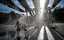 Pedestrians walk through water sprays on Place Bellecour during a heatwave in Lyon, central France on September 2, 2026. (Photo by OLIVIER CHASSIGNOLE / AFP)