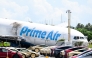 A parking lot filled with Tesla Cybercabs is seen in the foreground as the nose of a Prime Air cargo plane rests on the ground after the aircraft overran the runway and struck cars the previous day at Miami International Airport in Miami, Florida, on September 7, 2026. (Photo by CHANDAN KHANNA / AFP)