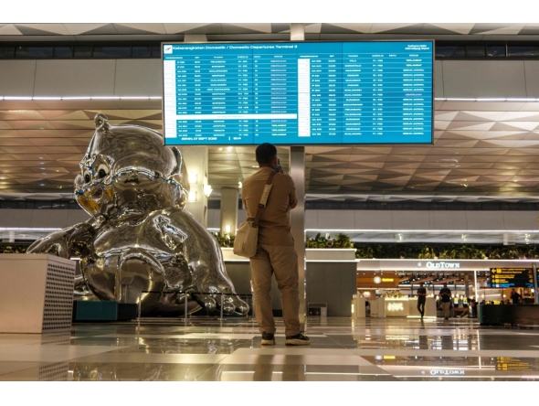 A stranded passenger looks at a flight information screen amid the closure of Soekarno-Hatta International Airport due to the eruption of the Mount Anak Krakatau volcano, in Tangerang on September 7, 2026. indonesia's main airport and several other air travel hubs reopened early on September 8 after days of closure due to ash from a volcanic eruption, the Transport Ministry said. (Photo by Taris HIRZIMAN / AFP)