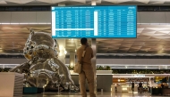 A stranded passenger looks at a flight information screen amid the closure of Soekarno-Hatta International Airport due to the eruption of the Mount Anak Krakatau volcano, in Tangerang on September 7, 2026. indonesia's main airport and several other air travel hubs reopened early on September 8 after days of closure due to ash from a volcanic eruption, the Transport Ministry said. (Photo by Taris HIRZIMAN / AFP)