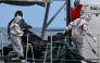 Philippine Coast Guard personnel in protective suits carry a body bag of a victim from the ferry fire to a tent for identification at the port of Borac in Coron, Palawan province on September 13, 2026. Photo by JAM STA ROSA / AFP