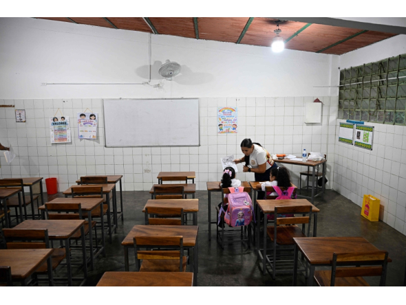 A teacher talks to her students during a class at the beginning of the school year in La Guaira, Venezuela on September 15, 2026.  (Photo by Federico PARRA / AFP)