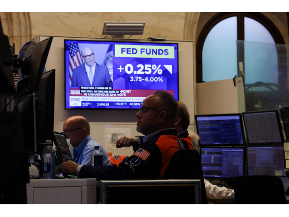 A television displays news of the US Federal Reserve's interest rate hike as traders work on the floor of the New York Stock Exchange (NYSE) in New York on September 16, 2026. (Photo by TIMOTHY A. CLARY / AFP)