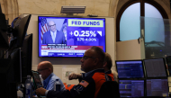 A television displays news of the US Federal Reserve's interest rate hike as traders work on the floor of the New York Stock Exchange (NYSE) in New York on September 16, 2026. (Photo by TIMOTHY A. CLARY / AFP)