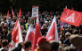 Workers wave flags of the industrial union IG Metall as they protest against job cuts in front of the commercial cars plant of German car maker Volkswagen (VW) on September 21, 2026 in Hanover, central Germany. (Photo by Ronny Hartmann / AFP)