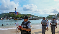 A member of the Mexican National Guard makes an announcement to residents and visitors about the approach of Hurricane Polo along a beach in Acapulco, Guerrero state, Mexico, on September 21, 2026.  (Photo by Francisco Robles / AFP)

