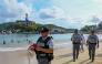 A member of the Mexican National Guard makes an announcement to residents and visitors about the approach of Hurricane Polo along a beach in Acapulco, Guerrero state, Mexico, on September 21, 2026.  (Photo by Francisco Robles / AFP)
