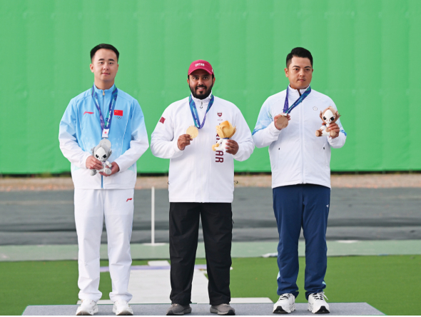 Individual skeet gold medalist Rashid Saleh Al-Athba (centre) of Qatar, silver medallist L Jianlin (left) of China and bronze winner L Meng-Yuan of Chinese Taipei celebrate on the podium. (XINHUA)