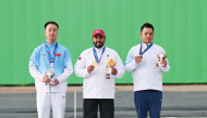 Individual skeet gold medalist Rashid Saleh Al-Athba (centre) of Qatar, silver medallist L Jianlin (left) of China and bronze winner L Meng-Yuan of Chinese Taipei celebrate on the podium. (XINHUA)