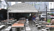 A man looks out from a flooded restaurant in Bangkok on September 26, 2026. (Photo by Lillian Suwanrumpha / AFP)