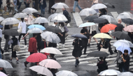 (Files) Pedestrians with umbrellas walk on a crossing as rain falls in Tokyo's Shibuya district on September 20, 2026. (Photo by Rie Kikuchi / AFP)