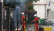 Firefighters extinguish a fire at the entrance of the Leonard de Vinci secondary school following a blockading action by protesting students, in Paris on October 2, 2026. (Photo by Thomas SAMSON / AFP)