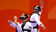 Japan's Nakajima Miho (L) competes against compatriot Suzuki Hayate (R) in the mixed individual virtual taekwondo round 16 during the 2026 Asian Games at the Toyohashi Gymnasium in Toyohashi on October 2, 2026. (Photo by DAVID GRAY / AFP)