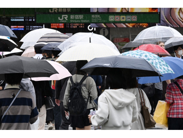 Pedestrians cross a road using umbrellas at the Shinjuku district in Tokyo on September 29, 2026, as strong Typhoon Surigae approaches Japan. (Photo by Toshifumi KITAMURA / AFP)
