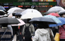 Pedestrians cross a road using umbrellas at the Shinjuku district in Tokyo on September 29, 2026, as strong Typhoon Surigae approaches Japan. (Photo by Toshifumi KITAMURA / AFP)
