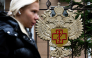 A woman walks past the logo of Russia's consumer and health watchdog Rospotrebnadzor sitting on its grounds' fencing in Moscow on October 5, 2026. Photo by Igor IVANKO / AFP