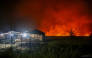 Flames and thick smoke glow against the night sky as a massive wildfire burns near residential structures in the Panarung area of Palangkaraya, Central Kalimantan province, on October 8, 2026. (Photo by REINA / AFP)
