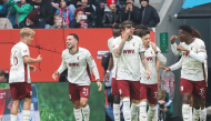Augsburg's German midfielder #19 Robin Fellhauer (hidden) celebrates scoring the opening goal with his teammates during the German first division Bundesliga football match. (Photo by Karl-Josef HILDENBRAND / AFP) 