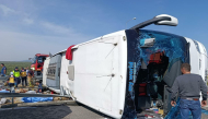 This handout photograph taken and released on October 11, 2026 by Turkish news agency DHA (Demiroren News Agency) shows fire department and first aid officials operating at the site of a crashed bus following the collision of a tour bus and a lorry in Manisa, west of Turkiye.  Photo by Handout / DHA (Demiroren News Agency) / AFP