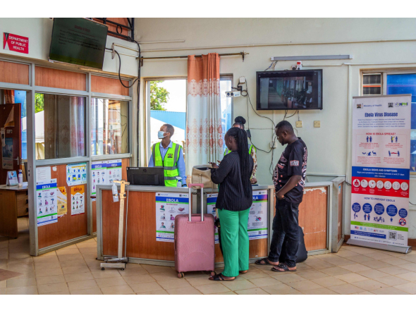 Travellers receive information from health officials near Ebola awareness posters before crossing the border at the Busia One Stop Border Post (OSBP) on the Kenya-Uganda border as health authorities step up Ebola screening measures, in Busia on October 12, 2026. (Photo by Bright Emoja / AFP)
