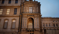 (Files) Police officers walk next to posts newly installed on the sidewalk along the Louvre Museum, on Quai Francois Mitterrand, in Paris on December 12, 2025. (Photo by Anna Kurth / AFP)