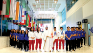 Equestrian rider Jassim Al Kuwari holds the Asian Games Flag alongside Team Qatar’s padel and women’s basketball players and students at the University of Doha for Science and Technology.