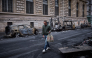 A man walks past a row of burnt out vehicles on Rue Yves Toudic destroyed after a nationwide protest against the 