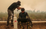 This picture taken on October 22, 2026 shows a volunteer from the Central Kalimantan Forest and Land Fire Smoke Response Coalition (RAKAT) providing mobile oxygen relief to a firefighter while battling forest and land fires in Palangkaraya, Central Kalimantan. (Photo by REINA / AFP)