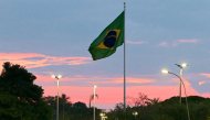 A Brazilian flag flies at sunset in Brasilia on October 24, 2026. (Photo by Pablo Porciuncula / AFP)
